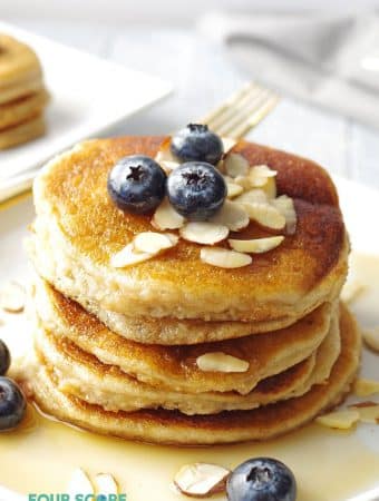 a close up of Stack of low carb pancakes topped with blueberries and sliced almonds