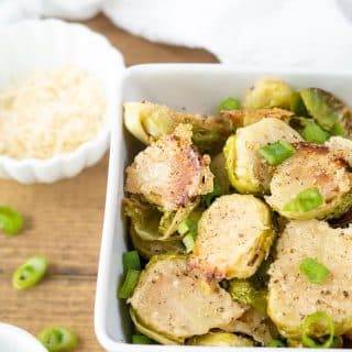 a close up of Parmesan Roasted Brussels Sprouts in a white bowl.