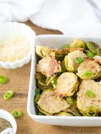 a close up of Parmesan Roasted Brussels Sprouts in a white bowl.