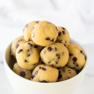 a close up of keto cookie dough bites in a white bowl