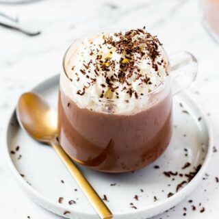 keto hot chocolate in a clear mug topped with whipped cream