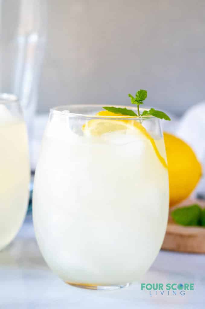 a close up of keto lemonade in a glass with lemon and mint