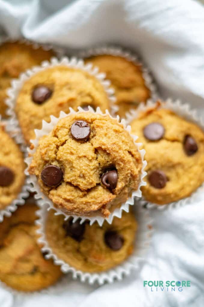 a close up of low carb pumpkin muffins with chocolate chips on a white dish towel
