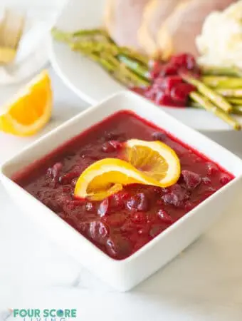 keto cranberry sauce in a white bowl with a orange slice
