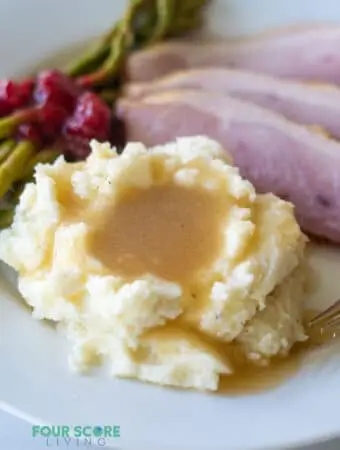 keto gravy over mashed cauliflower on a plate with ham
