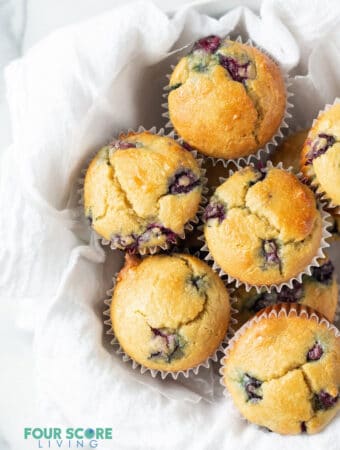 keto blueberry muffins in a white bowl with a white tea towel