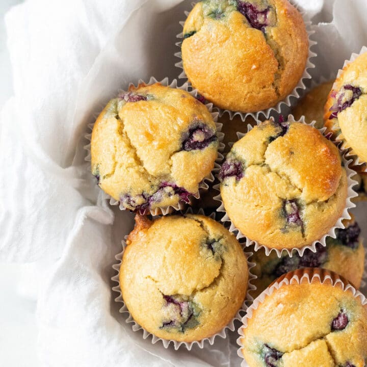 keto blueberry muffins in a white bowl with a white tea towel