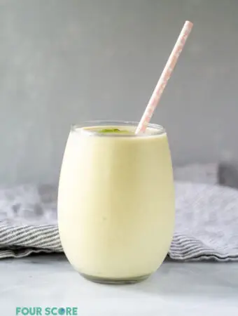 keto avocado smoothie in a glass with a straw