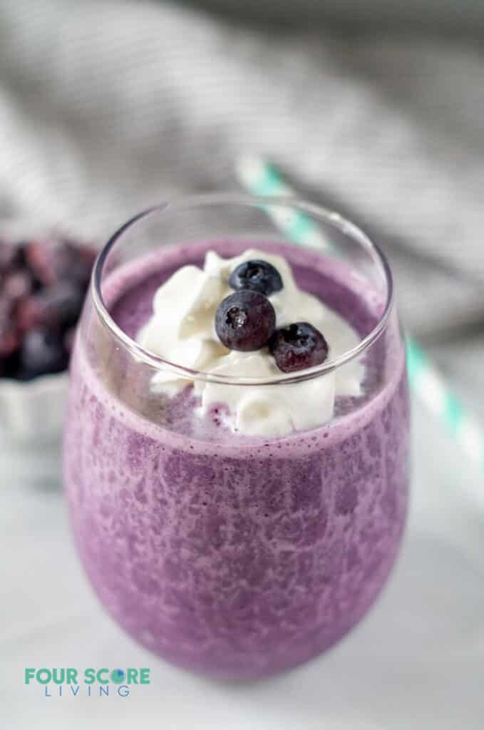 keto berry smoothie with whipped cream and blueberries on top