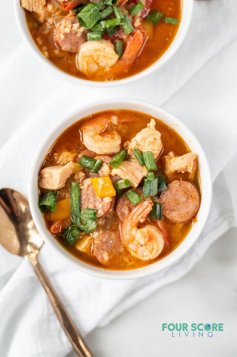 low carb jambalaya in a white bowl topped with chopped green onions