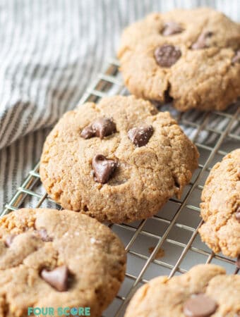 chocolate chip cookies on a wire rack over a striped gray towel