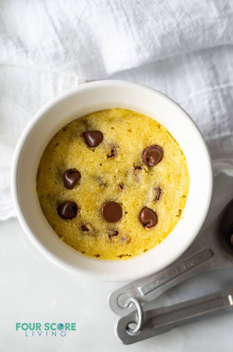 a low carb chocolate chip mug cookie in a round white mug