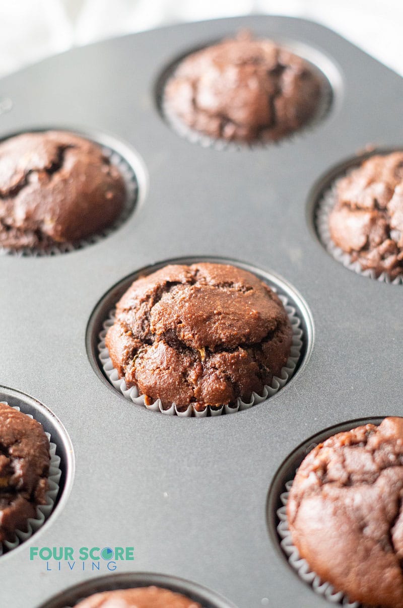 fresh baked chocolate zucchini muffins in a metal muffin pan