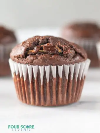 close up of a chocolate zuchinni muffin in a white cupcake liner