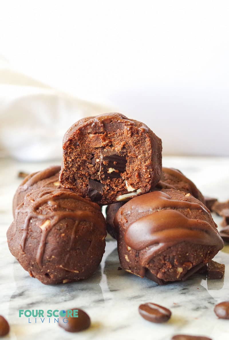 a pyramid of round bite sized chocolate balls with chocolate drizzle