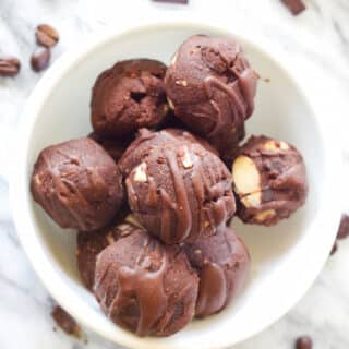 a close up of a white bowl filled with chocolate energy bites