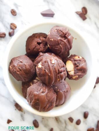 a close up of a white bowl filled with chocolate energy bites