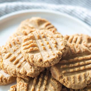 a pile of peanut butter cookies on a round white plate