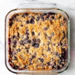 a clear square pan filled with a blueberry dump cake