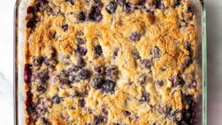 a clear square pan filled with a blueberry dump cake