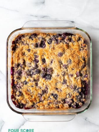 a clear square pan filled with a blueberry dump cake