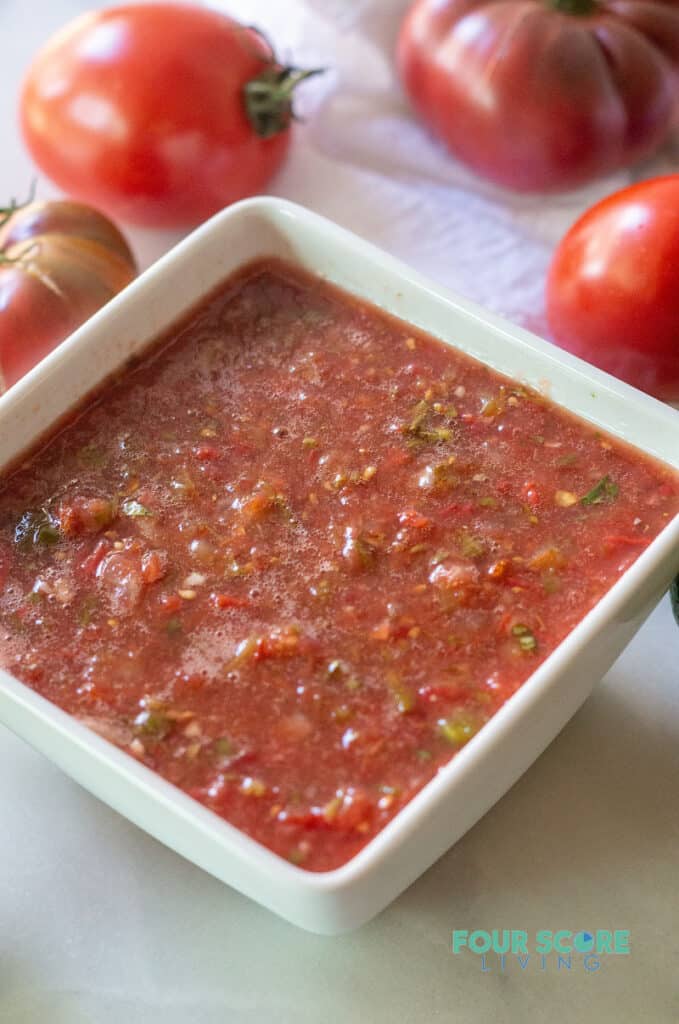 side view of salsa in a white square bowl to show the consistency