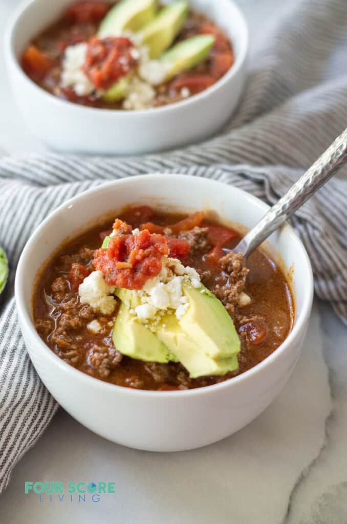 keto taco soup topped with avocado, salsa, and feta