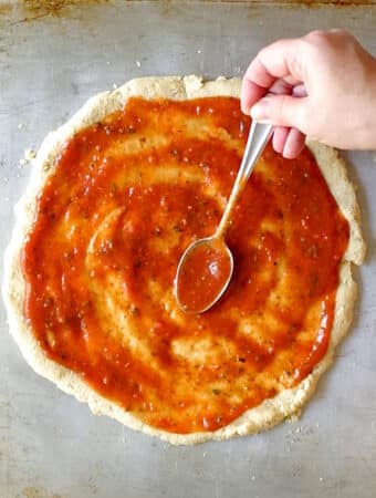keto pizza sauce on a a pizza crust