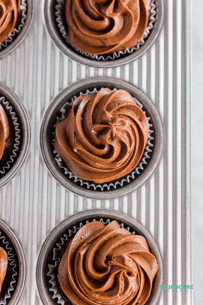 top down view of a chocolate frosted cupcake in a baking pan.