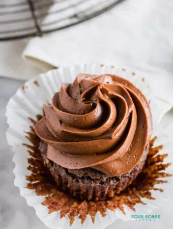 close up angle view of a keto chocolate cupcake with chocolate frosting