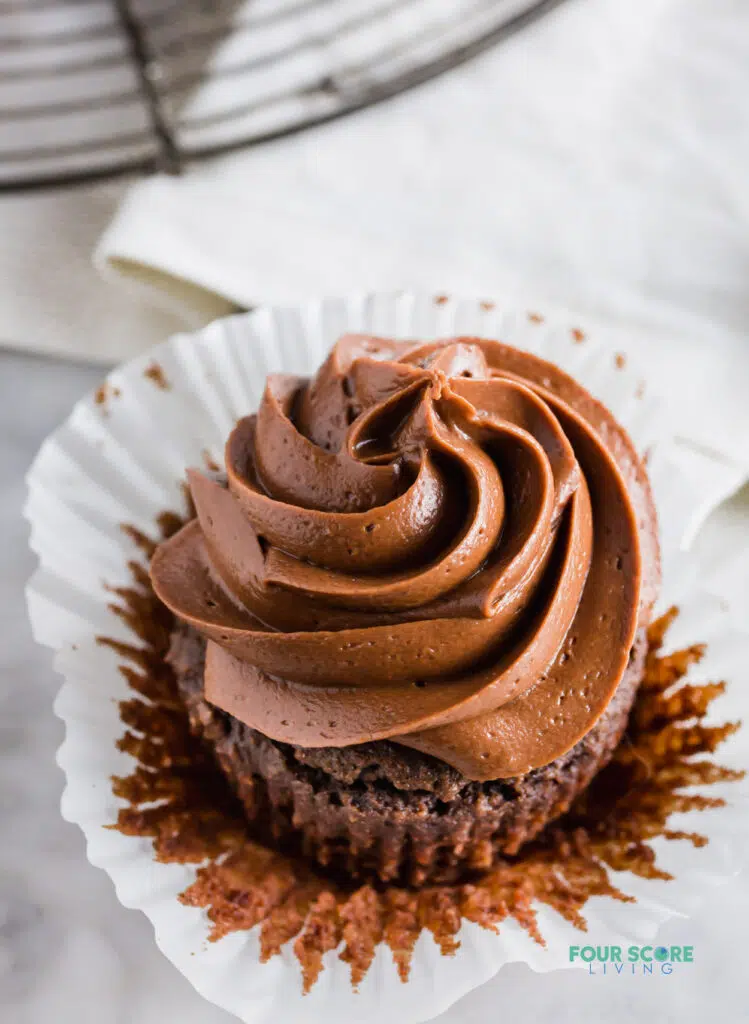 close up angle view of a keto chocolate cupcake with chocolate frosting