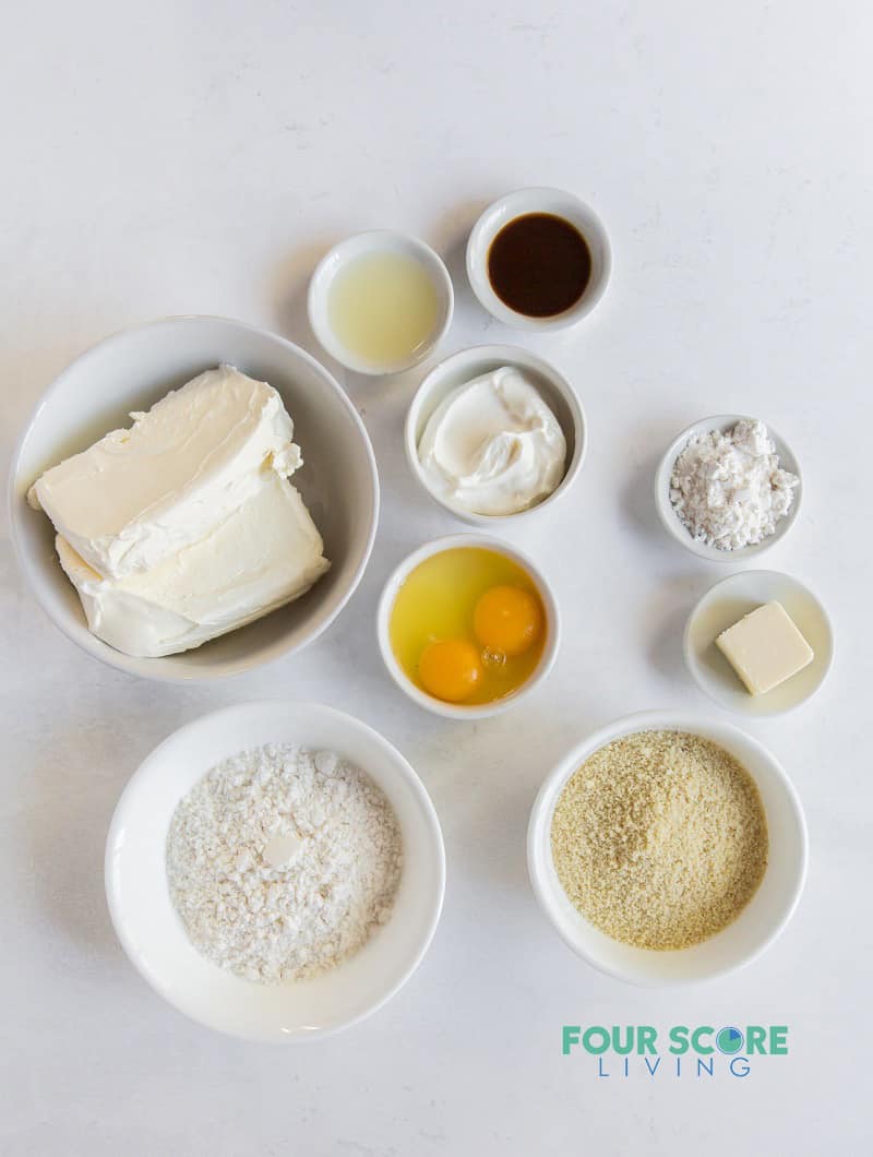 ingredients for cheesecake, in small bowls on a counter