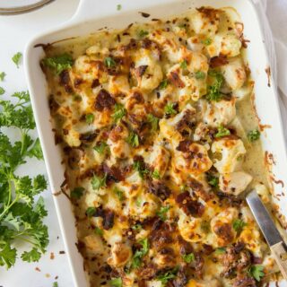 Rectangle casserole dish full of chicken bacon ranch casserole with cauliflower, on a table.