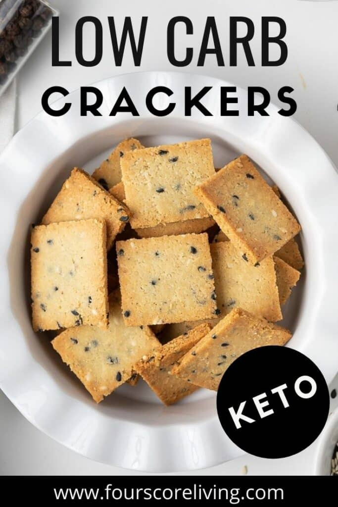 top down view of a white bowl filled with square crackers. Title on top of image states, Low carb crackers, keto.