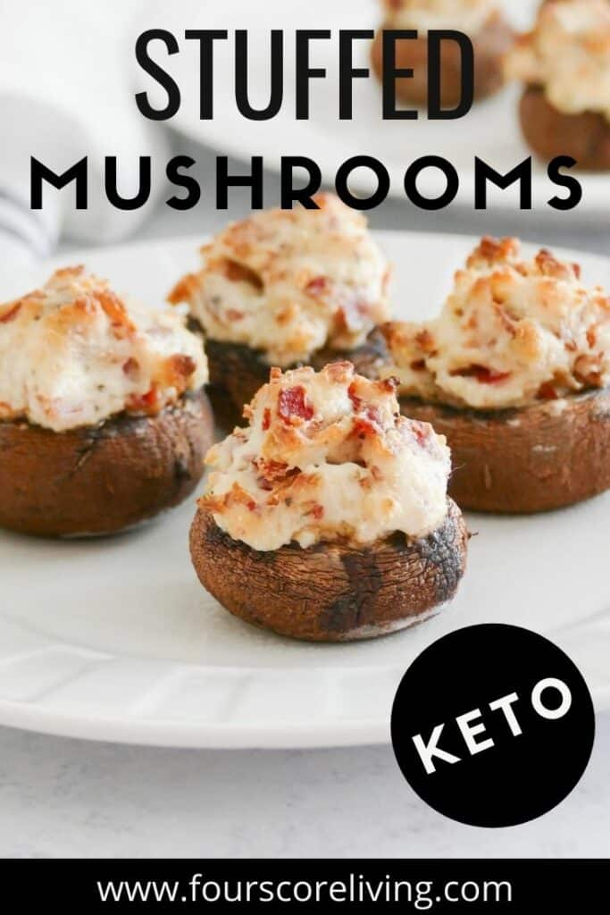 A round white plate of stuffed mushrooms filled with bacon and cheese, with the title, Stuffed Musrooms, Keto.