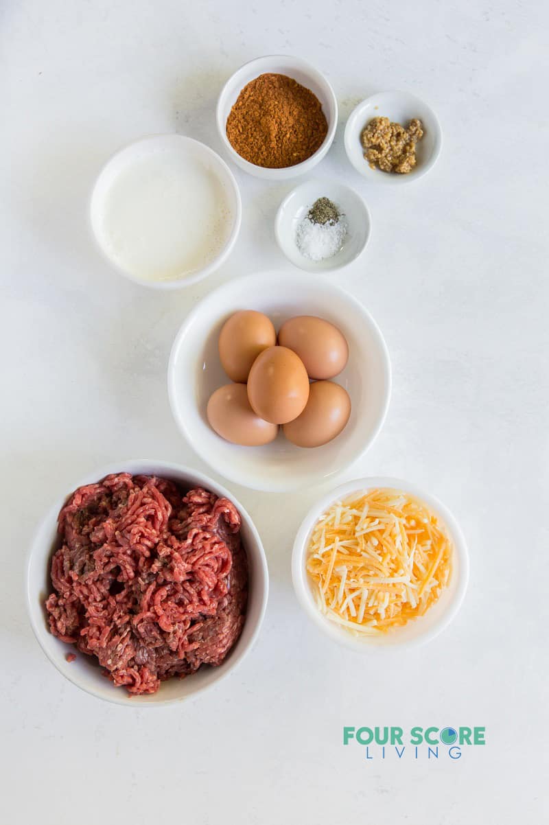 top down image of ingredients for taco pie, including ground meat, cheese, eggs, and seasonings. 