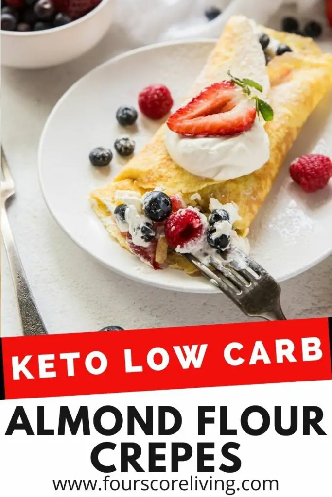A cream filled crepe on a white plate with mixed berries. Title on image reads, Keto Low carb almond flour crepes