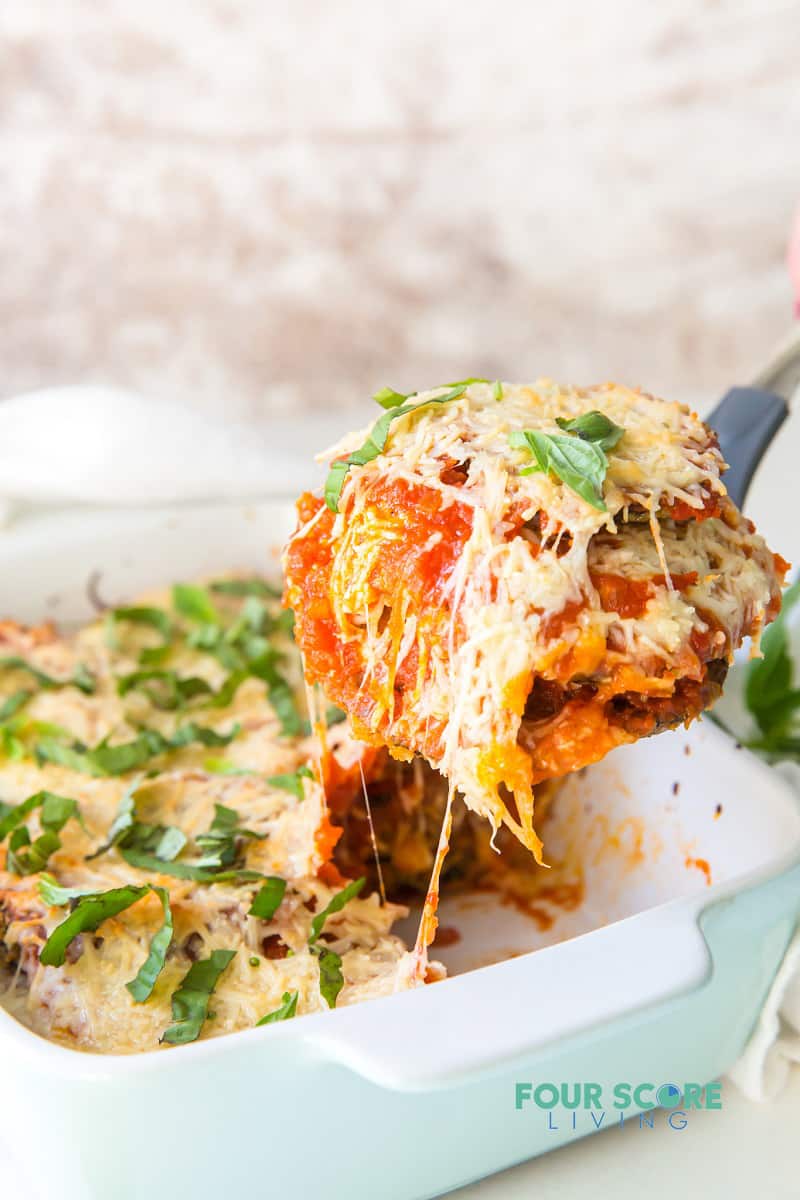 eggplant parmesan being served from a baking dish.