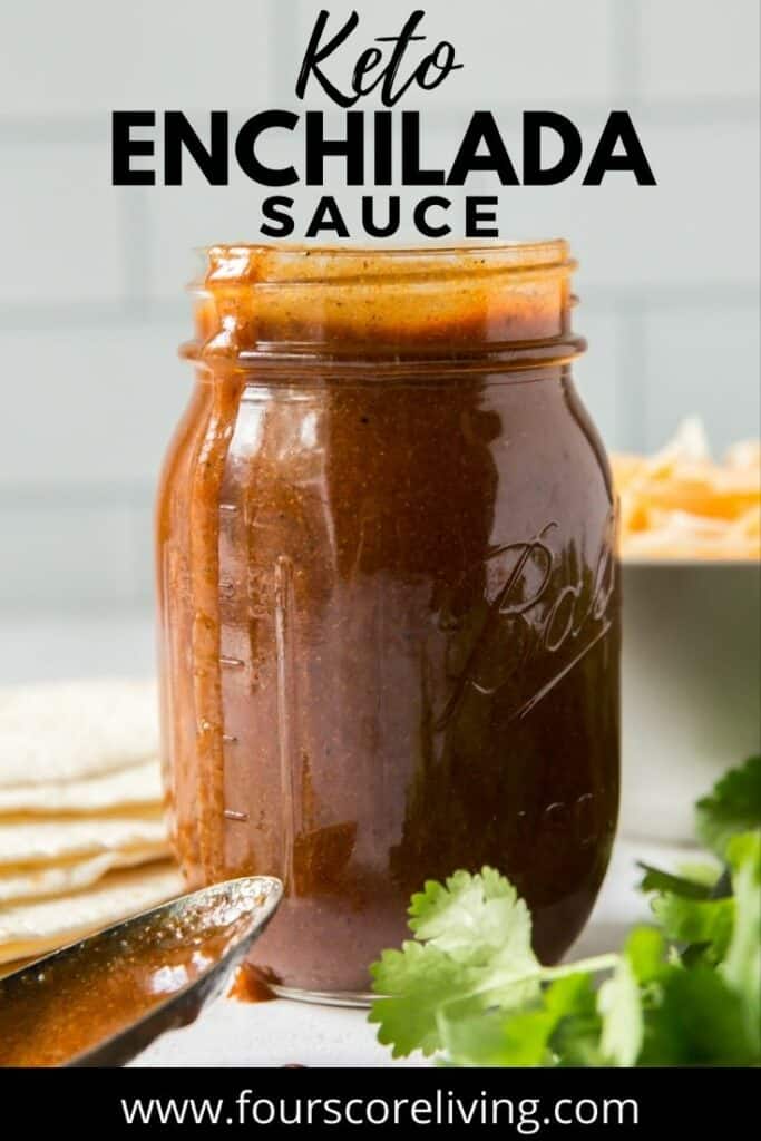 a jar of enchilada sauce on a counter. Title on image reads, Keto Enchilada Sauce