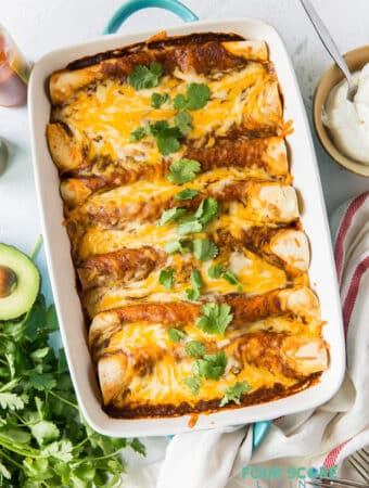 a full pan of enchiladas topped with melted cheese and cilantro garnish.