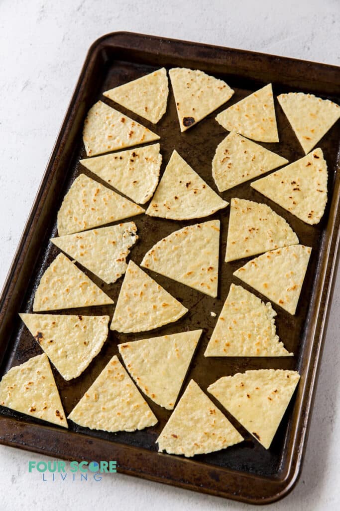 a sheet pan filled with tortilla triangles.