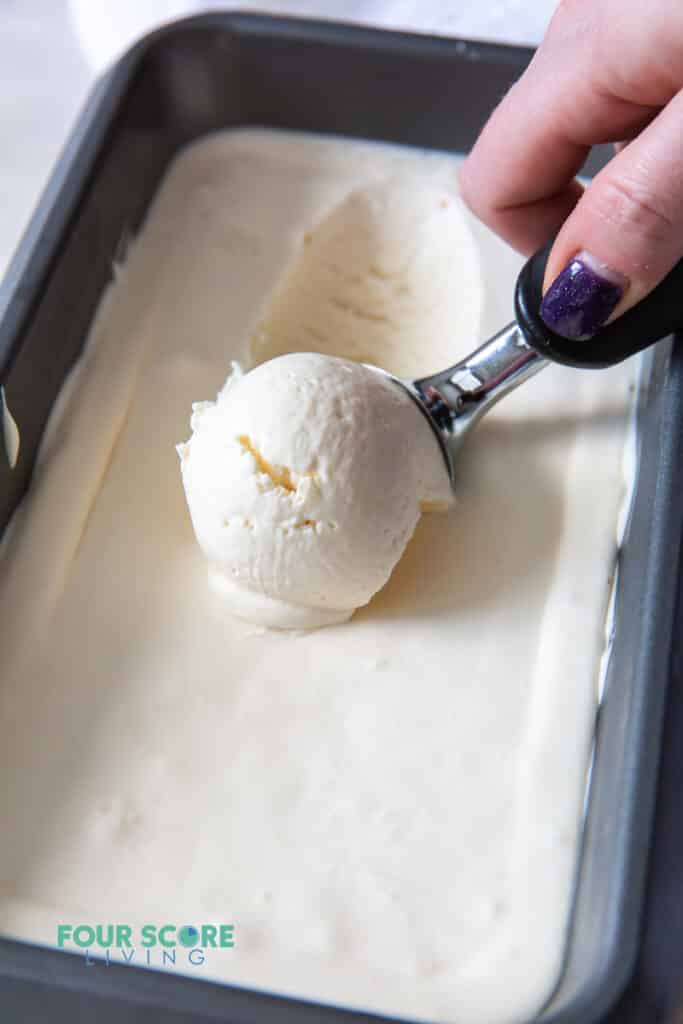 a pan of vanilla ice cream being scooped.