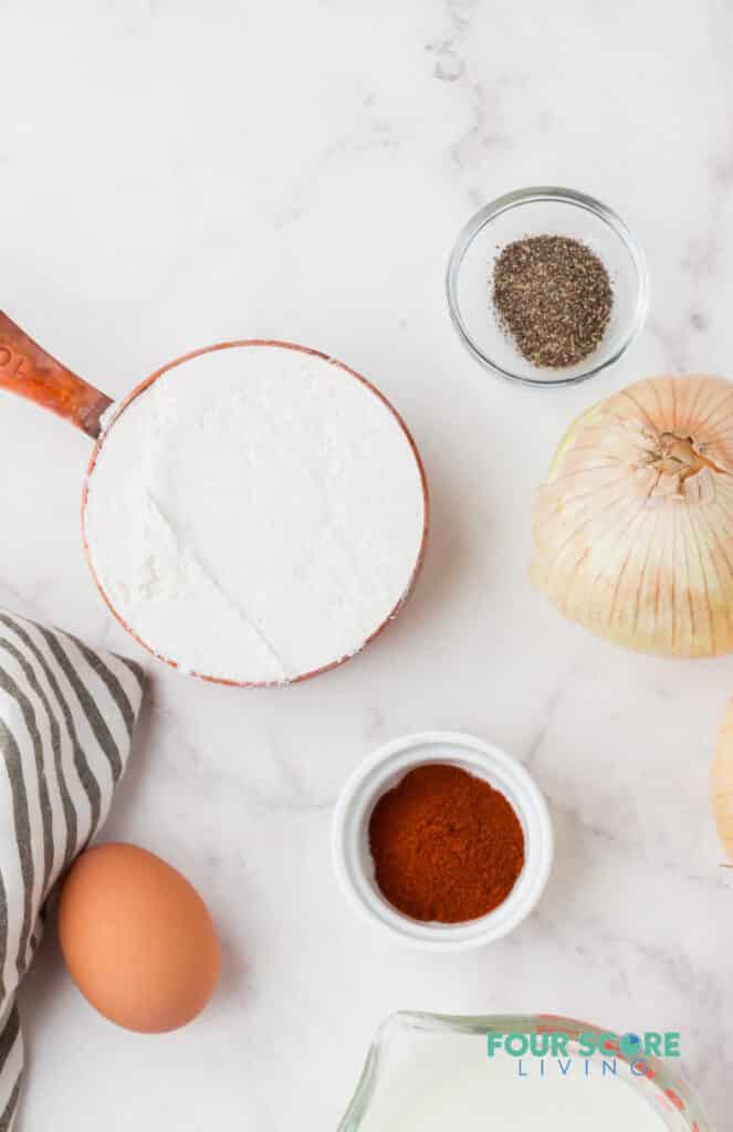 cornstarch in a cooper measuring cup next to pepper and onion