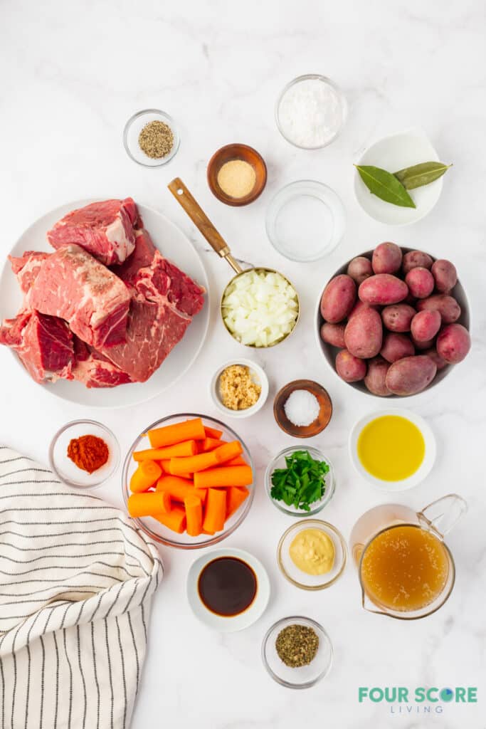 all of the ingredients for instant pot pot roast measured into separate dishes on a marble countertop