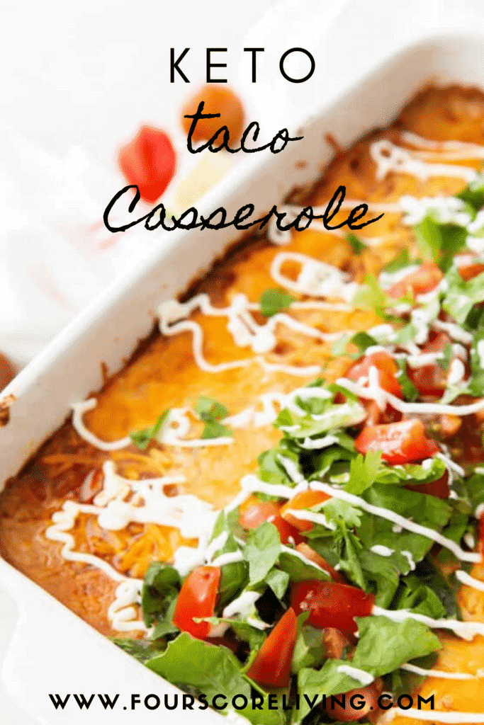 a casserole dish filled with cheesy taco casserole topped with lettuce and tomatoes