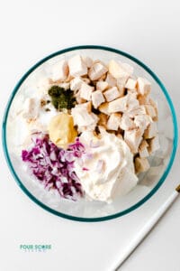 top down view of ingredients for keto chicken salad in a clear bowl