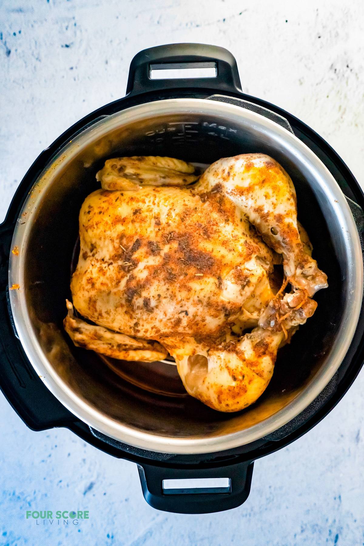 a whole cooked chicken inside of an instant pot, viewed from above