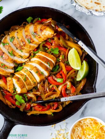 chicken and onions and peppers in a cast iron skillet