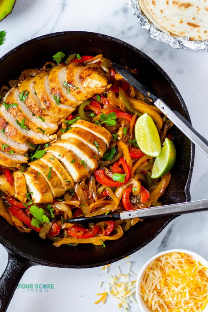 chicken and onions and peppers in a cast iron skillet