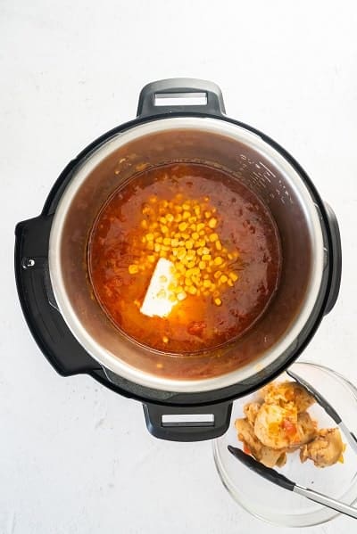 Top view photo of the Instant Pot with corn and cream cheese added to the pot.